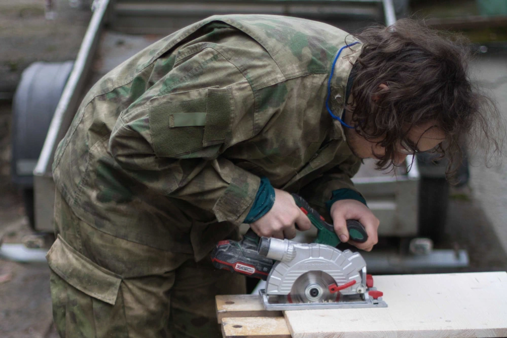 Vedúci sústredenia KMS pomáha účastníkom pri konštrukčnej hre